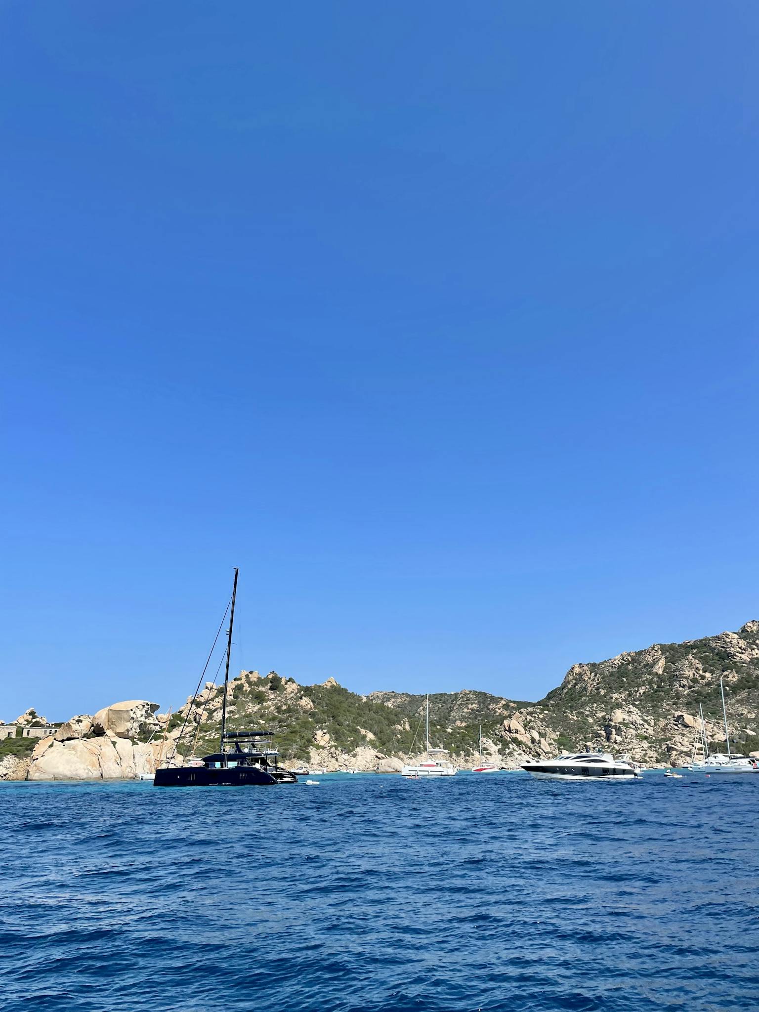 Explore the stunning seascape of La Maddalena, Sardinia with rocky cliffs and tranquil blue waters.